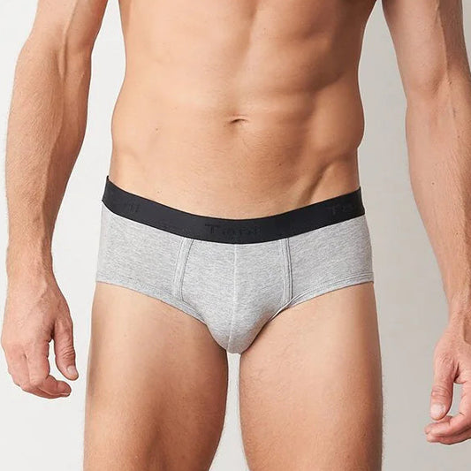 Man wearing gray underwear with a black waistband on a plain background