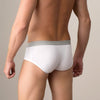 Man wearing white underwear against a beige background