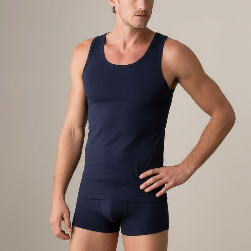 Man wearing a navy tank top and boxer briefs on a neutral background