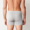 Person wearing gray boxer briefs against a plain background