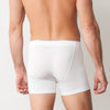 Man wearing white boxer briefs against a plain background