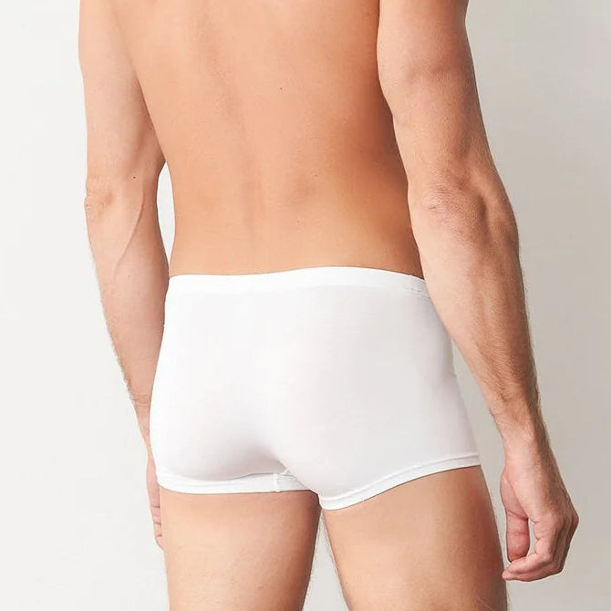 Man wearing white underwear against a plain background